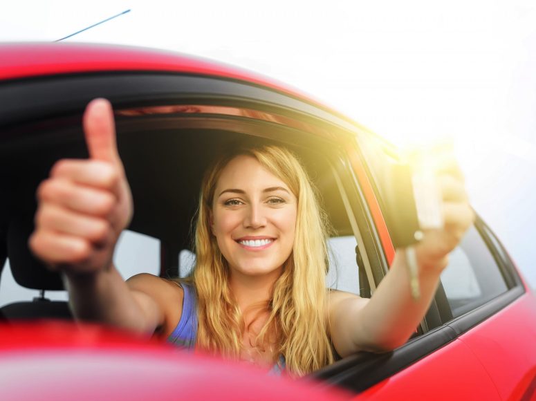 Gut gelaunte Frau, die den Daumen nach oben streckt, nachdem Autohaus Fischer ihr die Inzahlungnahme angenehm gestaltet hat.