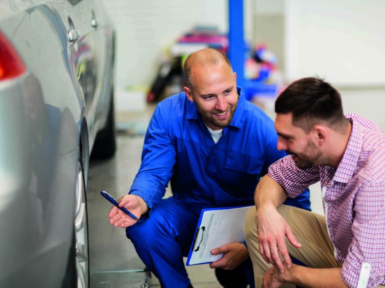 Mechaniker und Kunden besprechen Herstellergarantie beibehalten bei TOP Markenspezialist Autohaus Fischer. Spezialist für Renault, Dacia